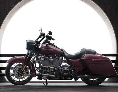 Two people riding red Honda motorcycle